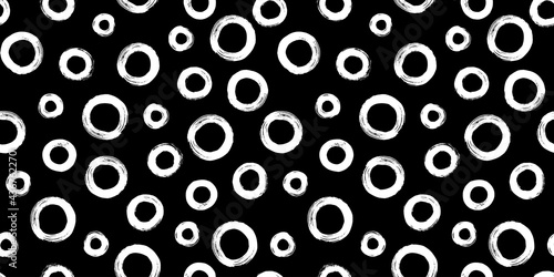 Black and white seamless pattern with rings in brush stroke technique. Abstract background with hand painted circles.