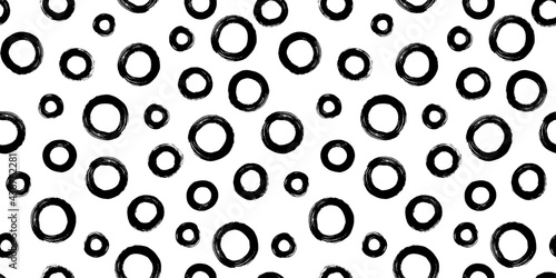 Black and white seamless pattern with rings in brush stroke technique. Abstract background with hand painted circles.