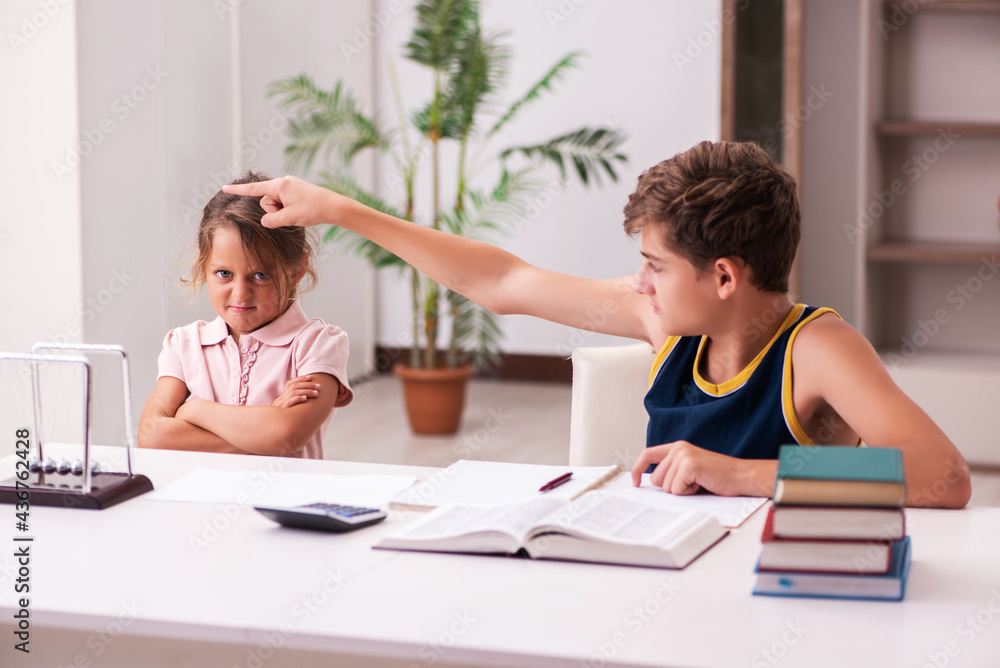 Schoolboy and his small sister staying at home during pandemic Schoolboy and his small sister staying at home during pandemic