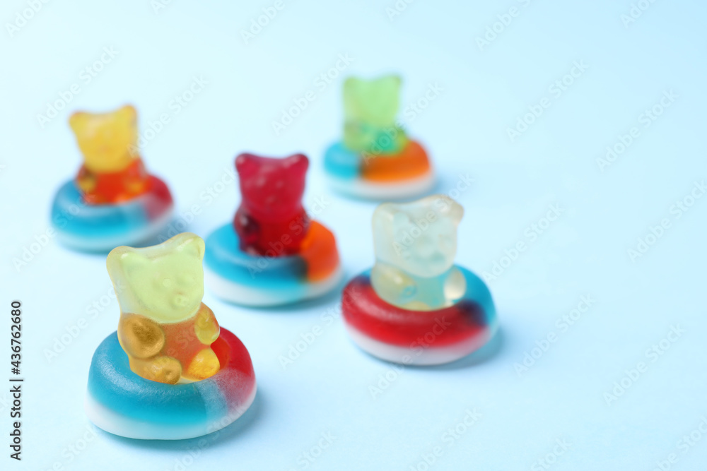 Jelly bears in rings as water donuts on light blue background Jelly bears in rings as water donuts on light blue background