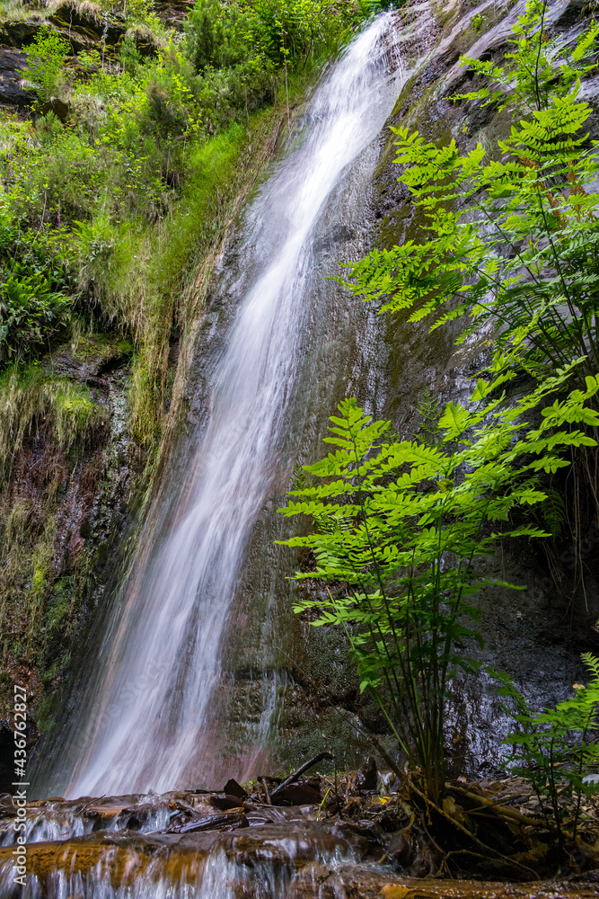 Water flows through a mountain waterfall Water flows through a mountain waterfall