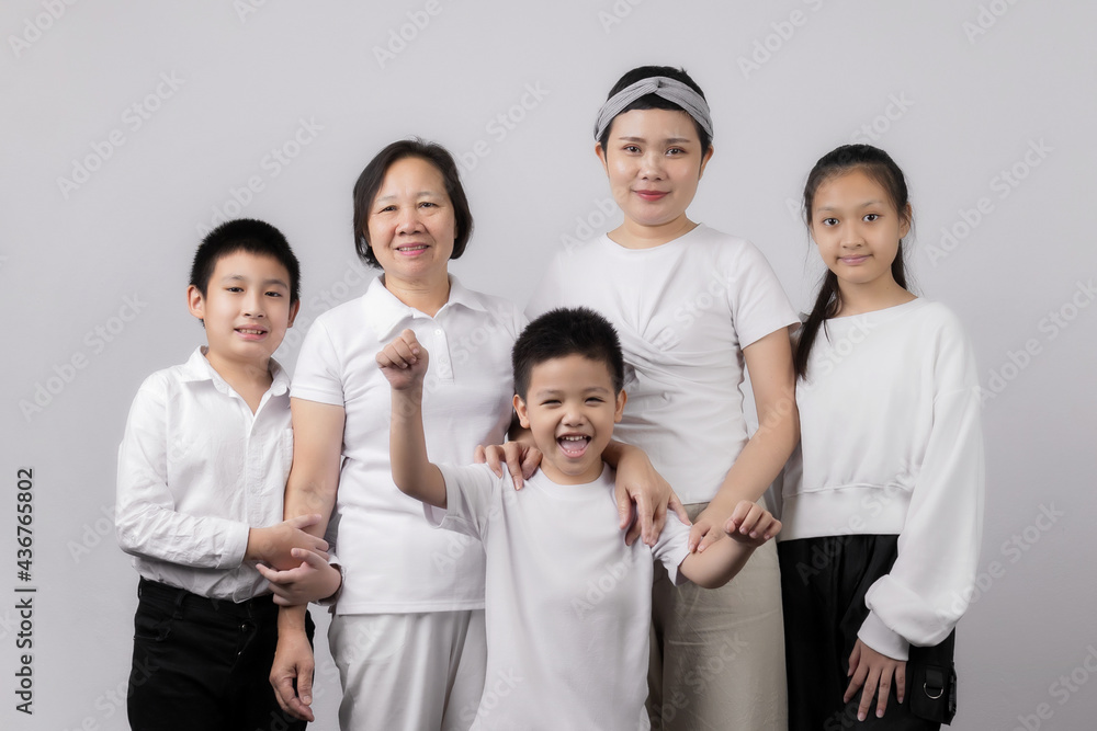 Portrait of Grandmother and grandchild hugging, looking at camera and smiling, on gray background Portrait of Grandmother and grandchild hugging, looking at camera and smiling, on gray background