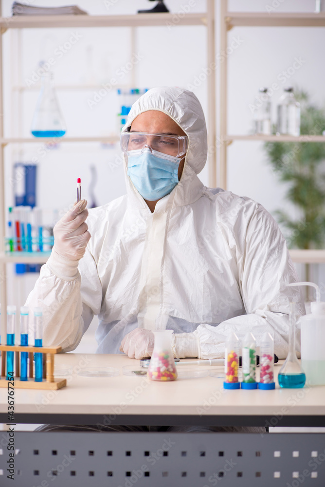 Young male chemist in drugs synthesis concept Young male chemist in drugs synthesis concept