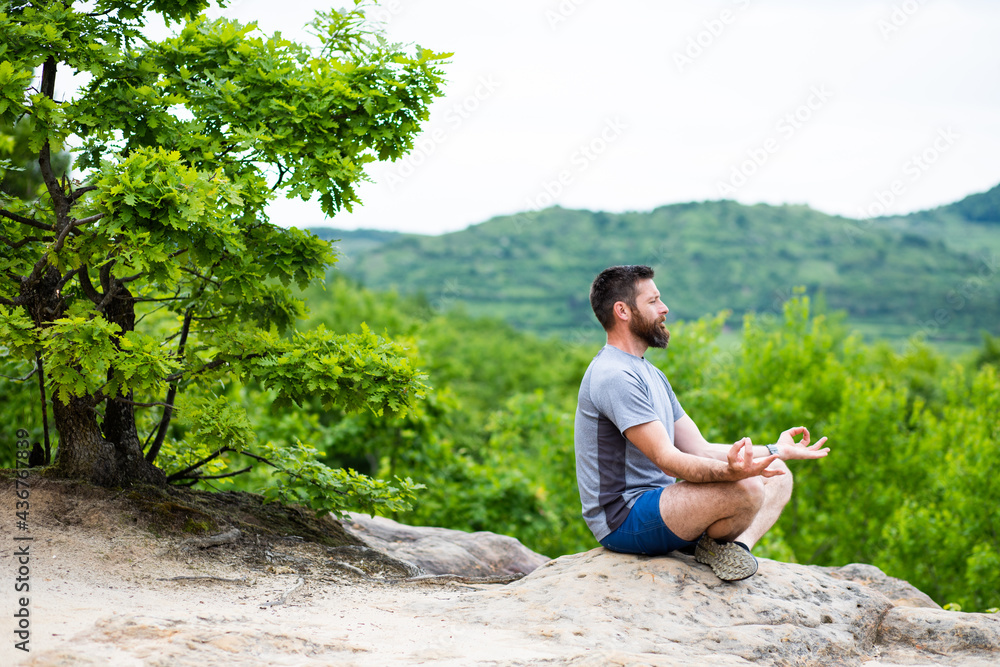 young man meditating outdoors