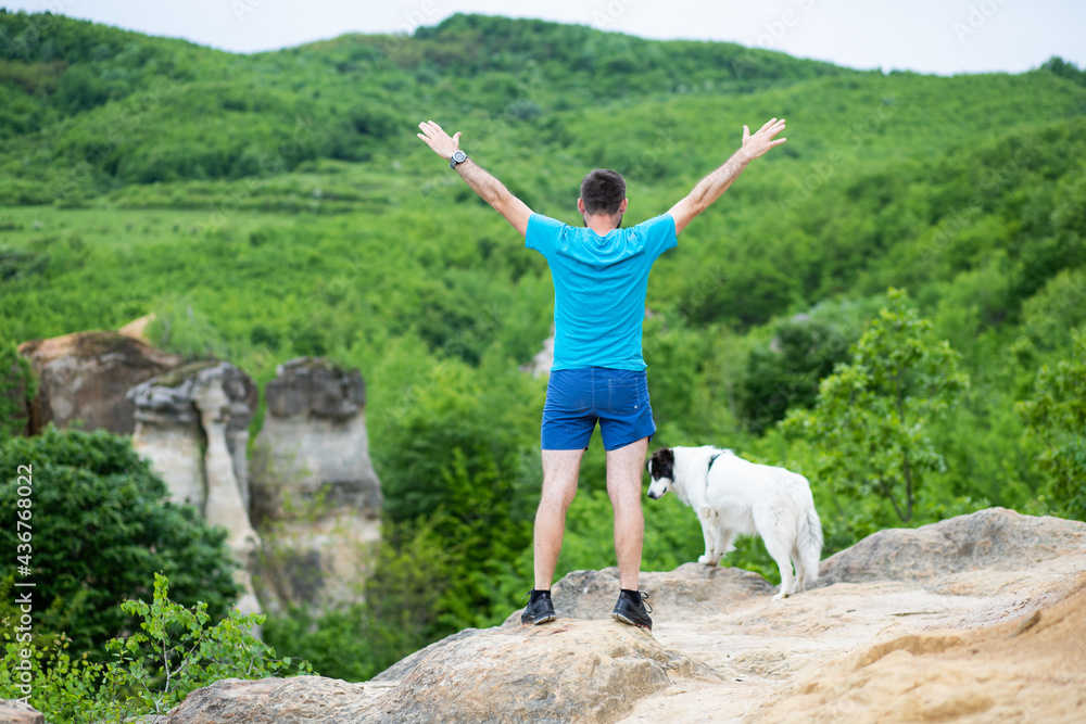 man with his dog sitting on a rock enjoying nature man with his dog sitting on a rock enjoying nature