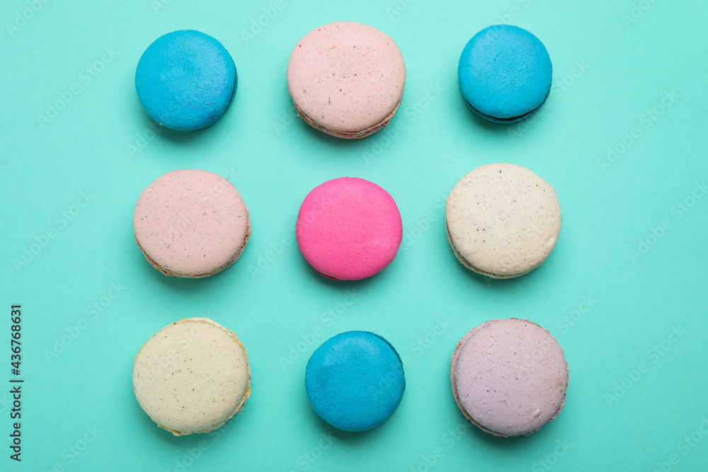 Delicious colorful macarons on turquoise background, flat lay Delicious colorful macarons on turquoise background, flat lay