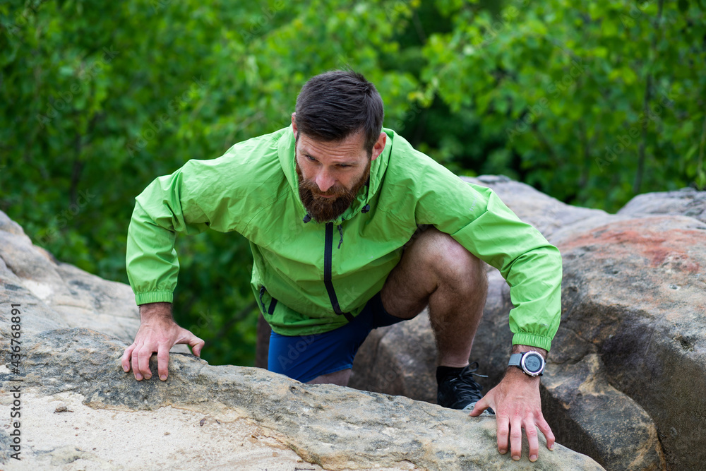 man climbing rocks in summer man climbing rocks in summer