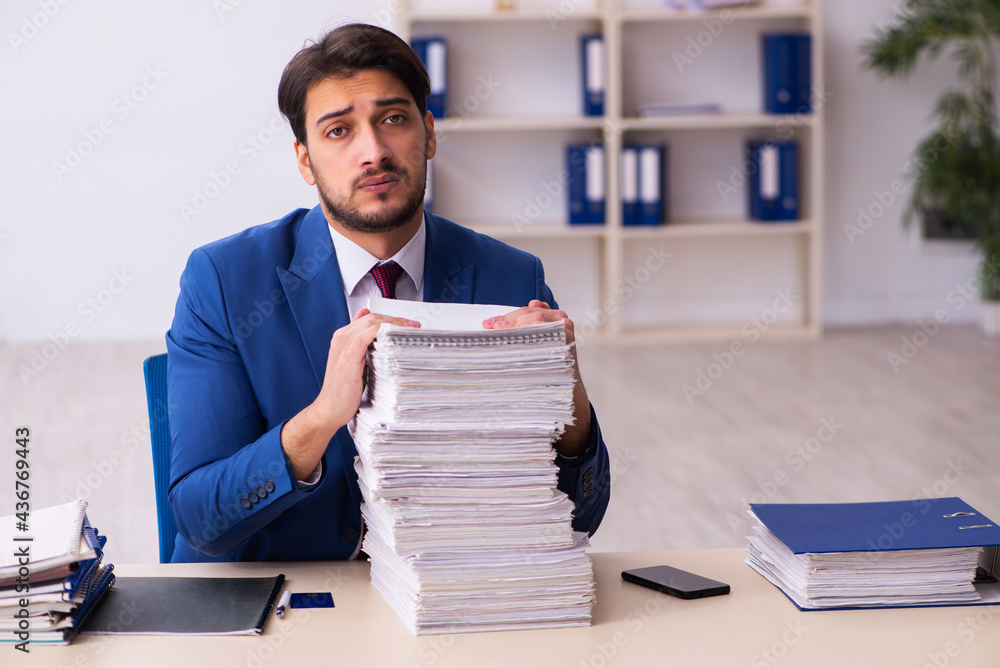 Young businessman employee and too much work in the office Young businessman employee and too much work in the office