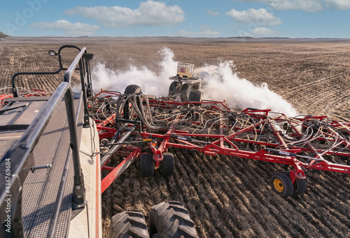 A farmer seeding his crop using Anhydrous Ammonia for fertilizer on a warm spring morning photo