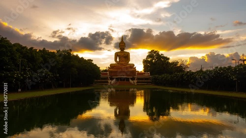 4K:Time lapse Beautiful  Big Golden Buddha statue against sunset clouds sky in Thailand temple,khueang nai District, Ubon Ratchathani province, Thailand. photo