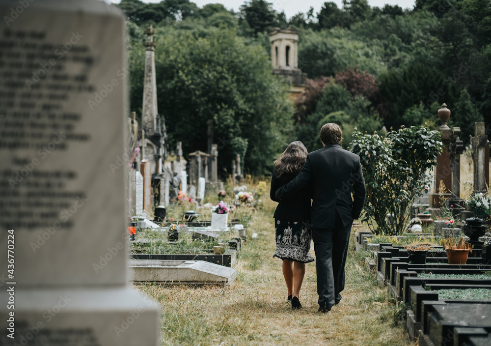Sad couple walking through a cemetery