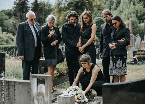 Family laying flowers on the grave photo