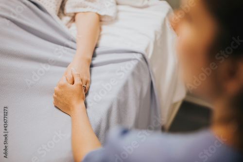 Nurse holding her patients hand