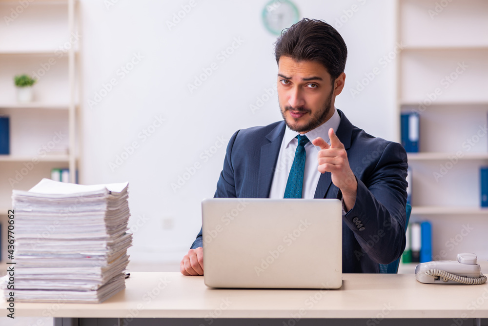 Young businessman employee and too much work in the office Young businessman employee and too much work in the office