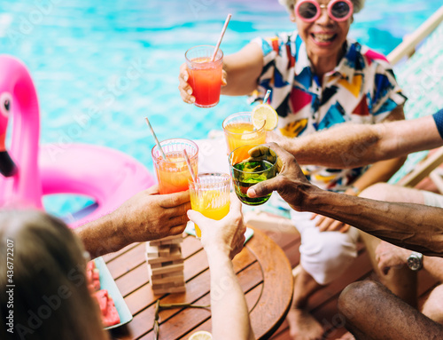 Canvas Print Group of diverse senior adult enjoying beverage by the pool together