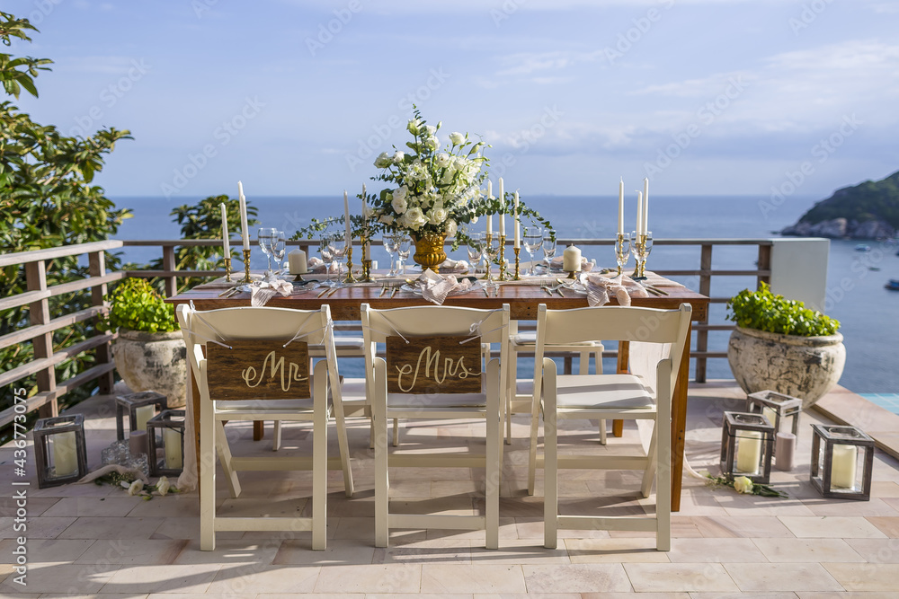 Romantic Wedding Table Top Layout Table Spread no people tropical location with gold cutlery and scenic sea view with copy space