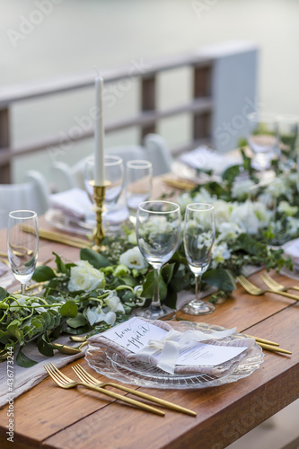 Romantic Wedding Table Top Layout Table Spread with flowers no people with gold cutlery white table cloth and scenic view of sunset and blue skies with copy space tablescape photo