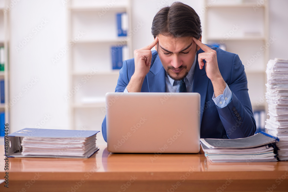 Young businessman employee and too much work in the office Young businessman employee and too much work in the office