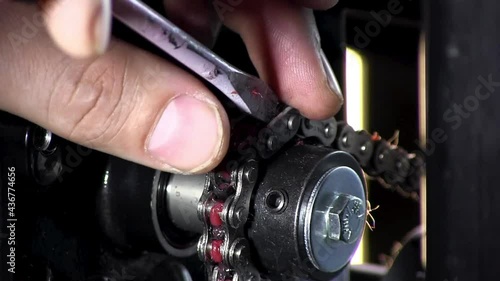 Fixing greased chain with Flathead screwdriver close up photo