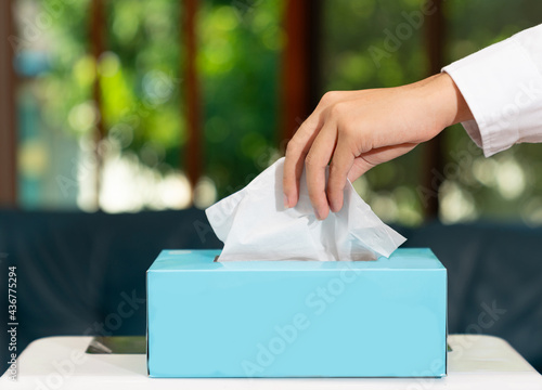 The man hand pulling a tissue box. photo