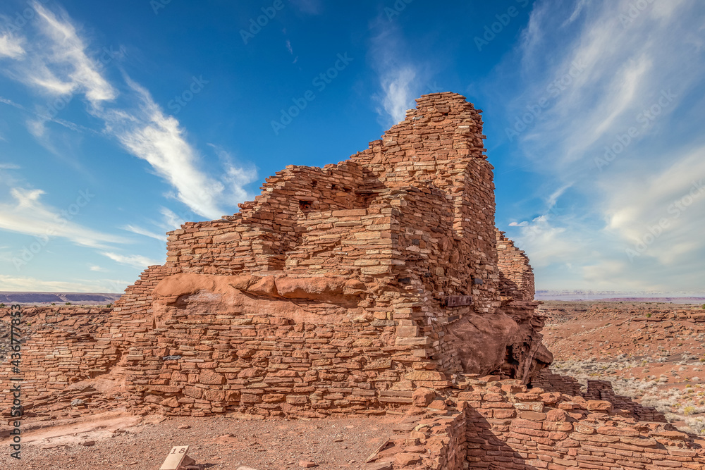 Wupatki National Monument located in north-central Arizona, near Flagstaff. Native American archaeological hilltop dwelling sites made from red stone built by ancient Sinagua pueblo people, blue sky Wupatki National Monument located in north-central Arizona, near Flagstaff. Native American archaeological hilltop dwelling sites made from red stone built by ancient Sinagua pueblo people, blue sky