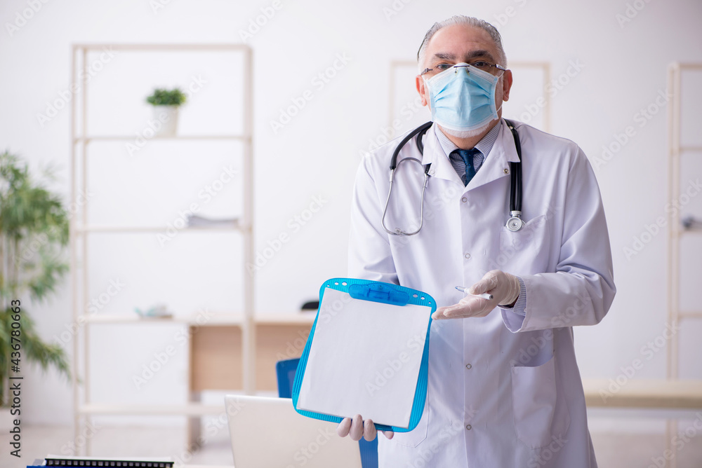 Old male doctor working in the clinic Old male doctor working in the clinic