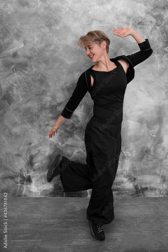 A woman in black clothes does a contemporary dance