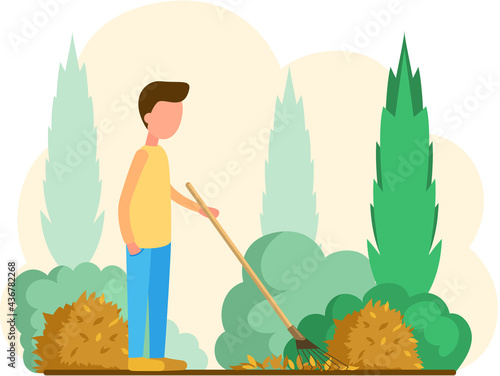 Young man doing seasonal garden work, remove leaves with rake, works on yard with trees. Agricultural worker in autumn tidies up garden, removes fallen yellow leaves stands near trees and bushes