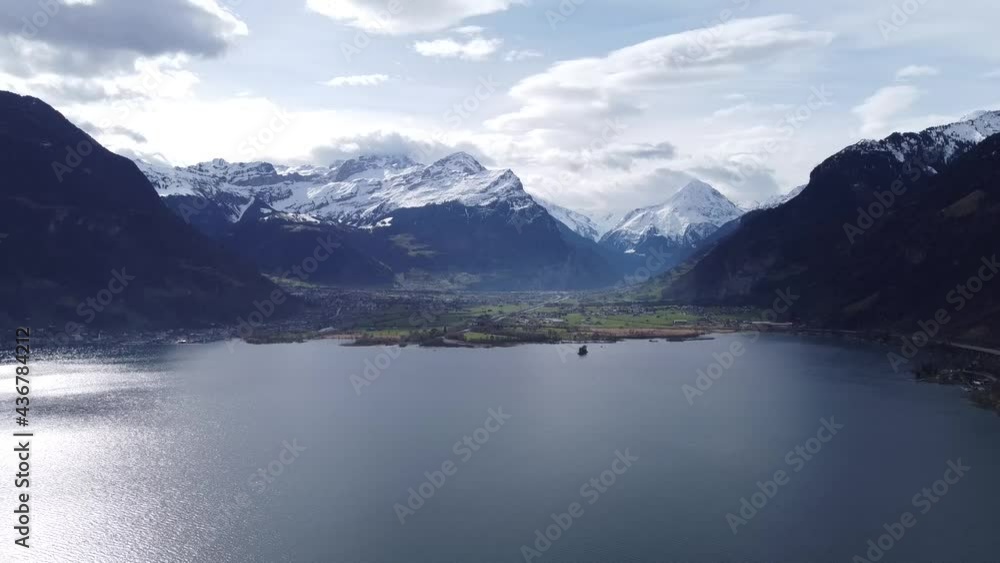 Snow-capped mountains with the famous Bristen summit, thrones over the deep blue Uri Lake, drone shot in Switzerland Snow-capped mountains with the famous Bristen summit, thrones over the deep blue Uri Lake, drone shot in Switzerland