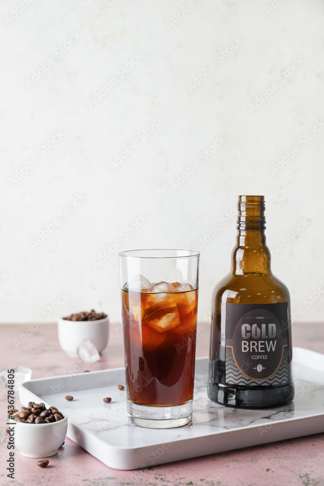 Glass and bottle of cold brew coffee on table Glass and bottle of cold brew coffee on table