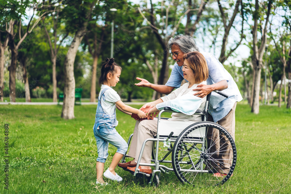 Portrait of happy asian grandfather with grandmother and asian little cute girl enjoy relax in summer park.Young girl with their laughing grandparents smiling together.Family and togetherness Portrait of happy asian grandfather with grandmother and asian little cute girl enjoy relax in summer park.Young girl with their laughing grandparents smiling together.Family and togetherness