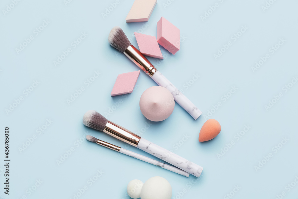 Makeup sponges with brushes on color background Makeup sponges with brushes on color background