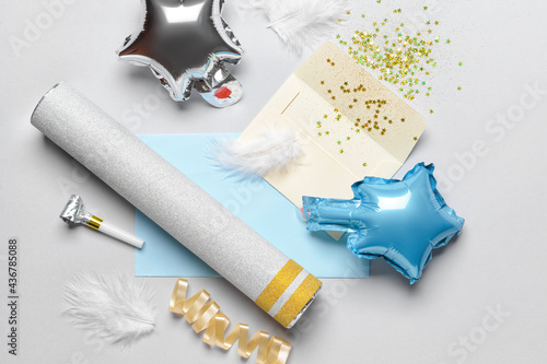 Party set with confetti and envelope on light background