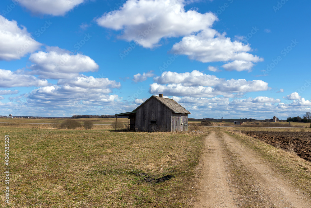 An old abandoned small wooden house in the field blue sky white clouds, barn or scary concept. An old abandoned small wooden house in the field blue sky white clouds, barn or scary concept.