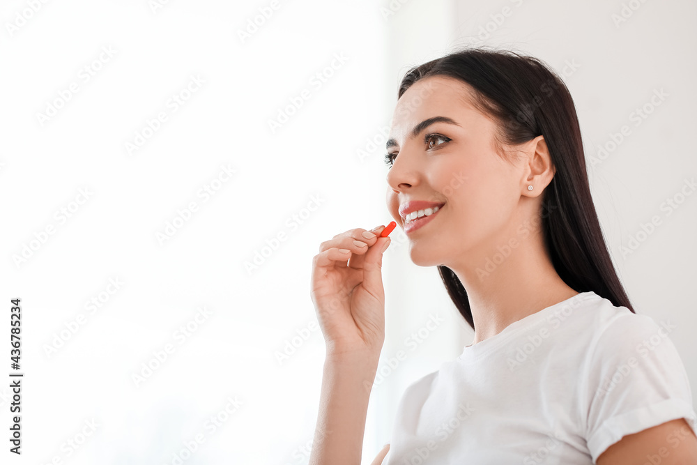 Beautiful young woman taking pills at home Beautiful young woman taking pills at home