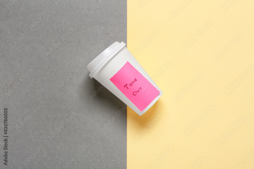 Blank paper cup with text TAKE OUT on color background Blank paper cup with text TAKE OUT on color background