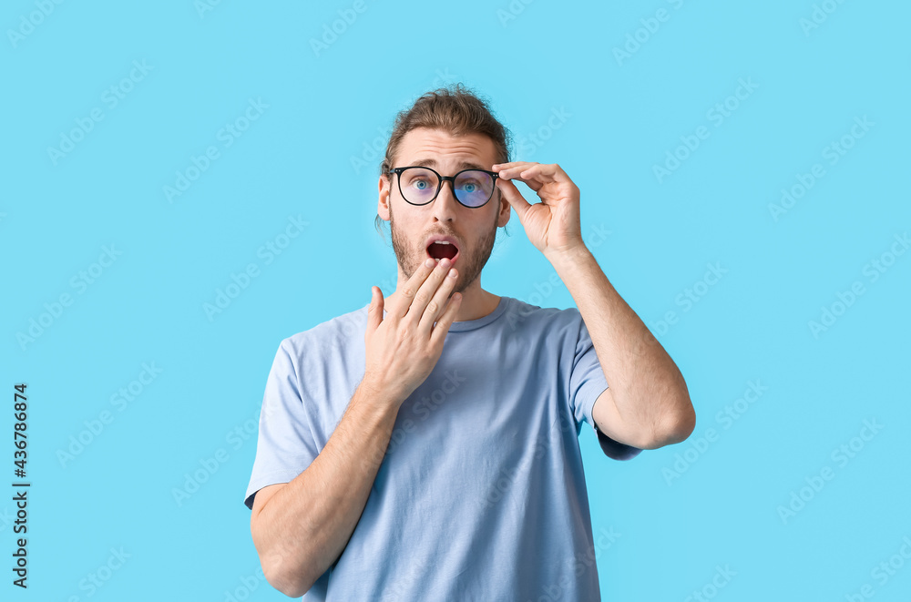Surprised young man with eyeglasses on color background Surprised young man with eyeglasses on color background