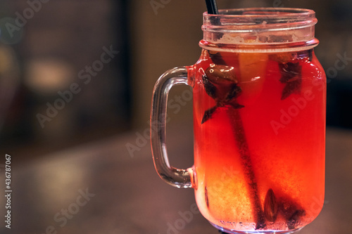 Christmas drink red non-alcoholic mulled wine with a straw on the background of the cafe interior, order for one