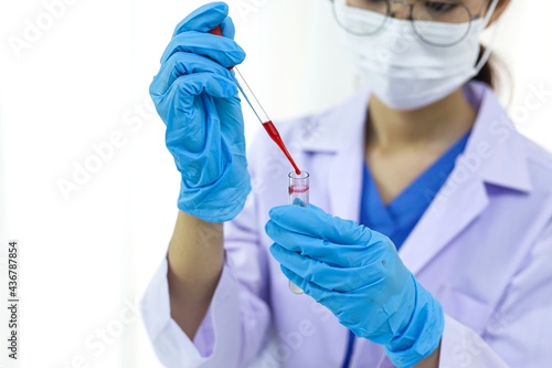 Scientist holding Coronavirus covid-19 infected blood sample tube DNA testing of the blood in the laboratory with blood sample collection tubes and syringe Coronavirus Covid-19 vaccine research.