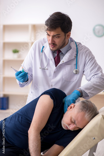 Old male patient visiting young male doctor in vaccination conce