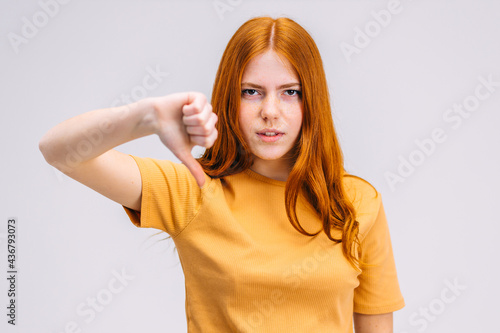 Wallpaper Mural Unhappy teenager girl showing thumbs down, looking down with neg Torontodigital.ca