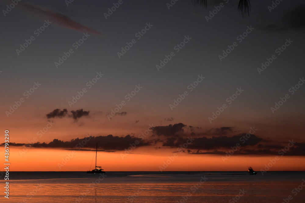 Golden sky of a sunset at sea with a catamaran silhouette, vacation at sea, private cruise background Golden sky of a sunset at sea with a catamaran silhouette, vacation at sea, private cruise background