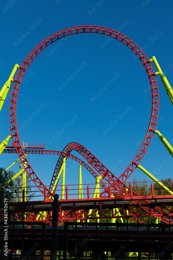 Obraz premium Vertical shot with a roller coaster loop on a blue sky background closeup
