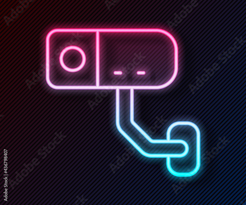 Glowing neon line Security camera icon isolated on black background. Vector