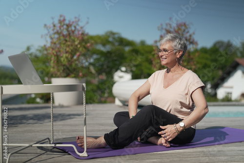 portrait of a 55 year old senior woman doing fitness outside her house