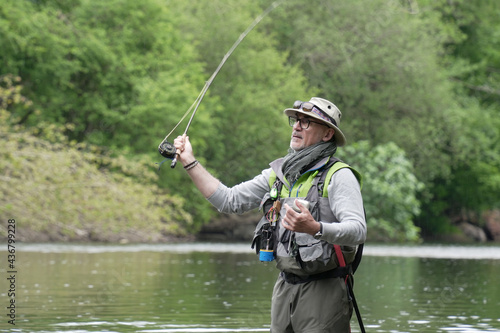 man fly fishing for trout in a clear river