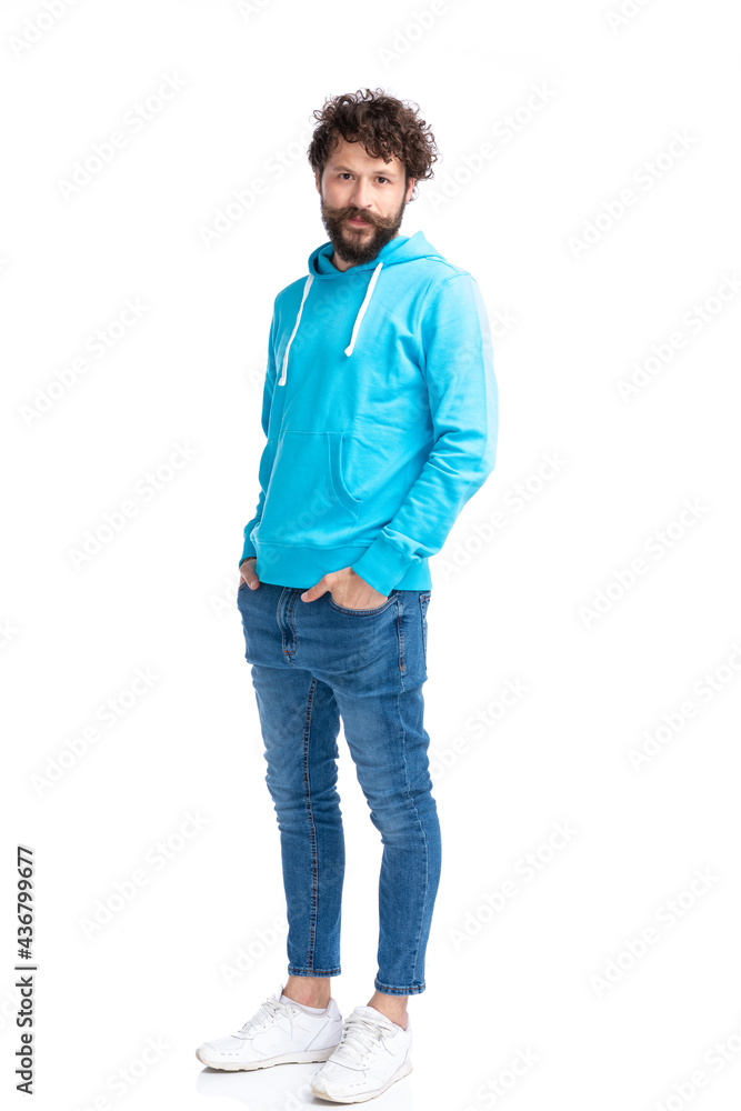 sexy young man in blue sweatshirt holding hands in pockets sexy young man in blue sweatshirt holding hands in pockets