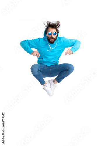 bearded casual man in hoodie snapping fingers and jumping in the air