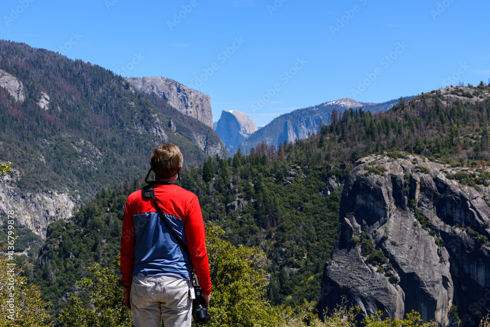 Hiker  admiring at Half Dome in Yosemite National Park in springtime, California