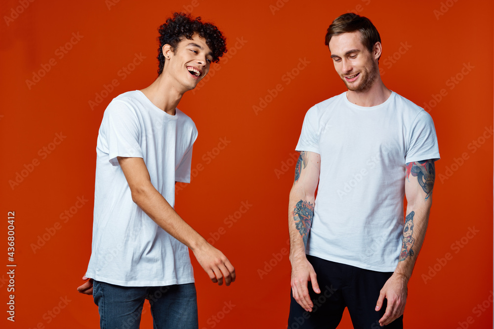 Two cheerful friends in t-shirts communicating emotions red background Two cheerful friends in t-shirts communicating emotions red background